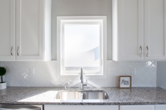 Kitchen sink flooded with natural lighting from a Vector window