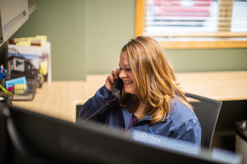 Smiling customer service employee helping a client over the phone